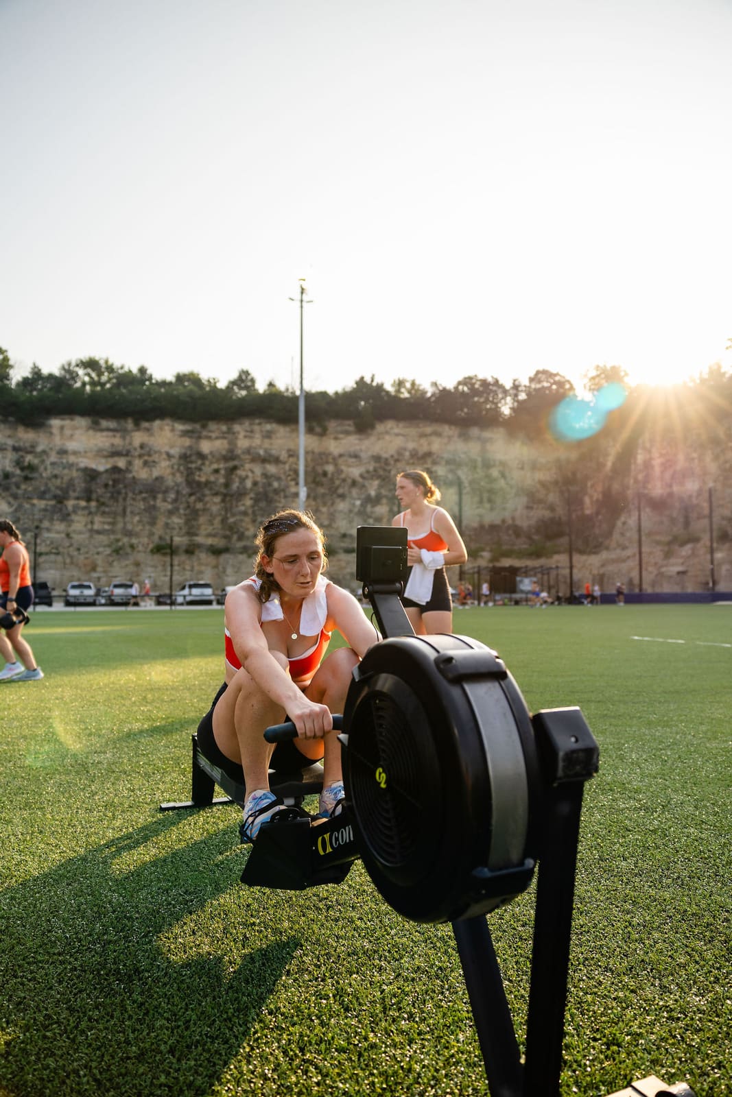 An athlete rowing in golden-hour sunlight against the quarry wall